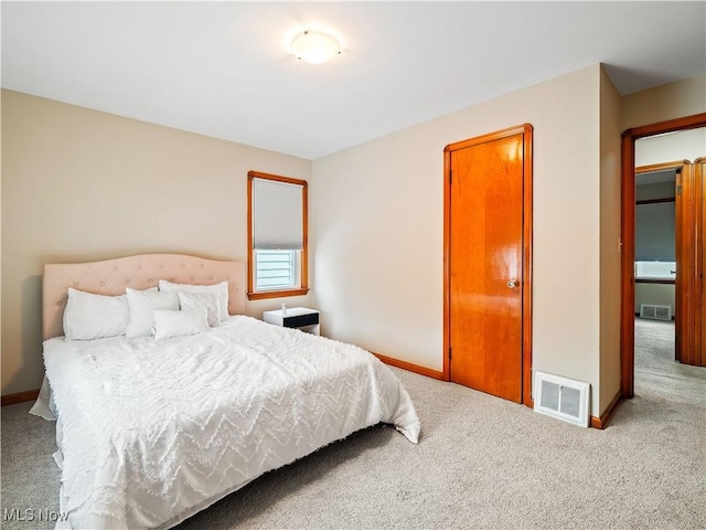 carpeted bedroom featuring baseboards and visible vents