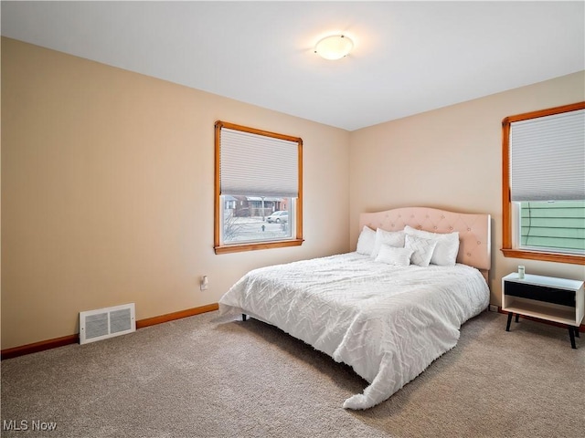 bedroom with carpet, visible vents, and baseboards