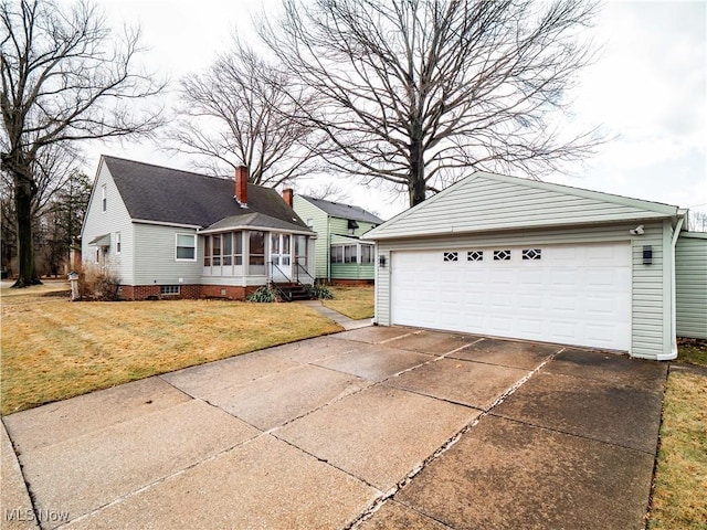 ranch-style house with an outbuilding, a detached garage, a sunroom, a chimney, and a front yard