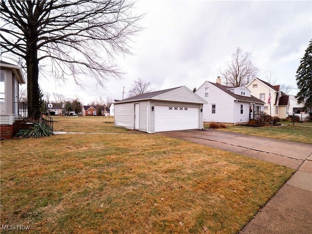 view of side of property featuring a garage, a yard, an outdoor structure, and a residential view