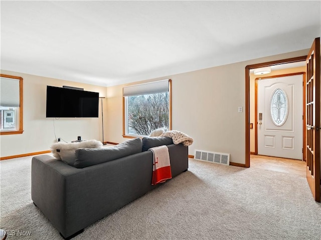 carpeted living room with visible vents and baseboards