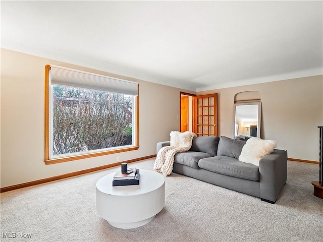 living room featuring carpet and baseboards