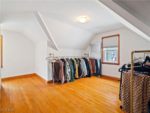 spacious closet with vaulted ceiling and light wood-style flooring