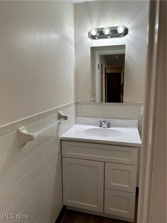 bathroom with tile walls, wainscoting, and vanity