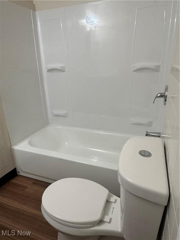 bathroom featuring shower / bathtub combination, wood finished floors, and toilet