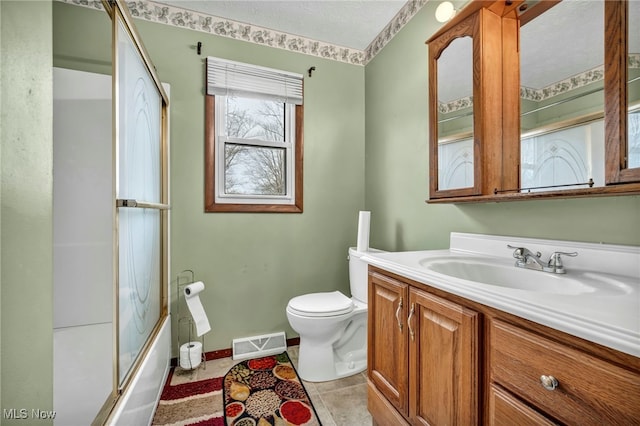 full bathroom featuring toilet, vanity, visible vents, combined bath / shower with glass door, and tile patterned floors