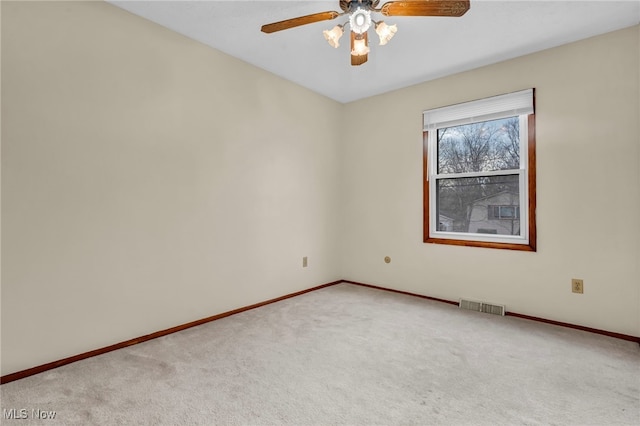 spare room featuring carpet, visible vents, ceiling fan, and baseboards