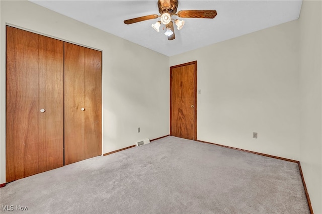 unfurnished bedroom with ceiling fan, visible vents, baseboards, a closet, and carpet