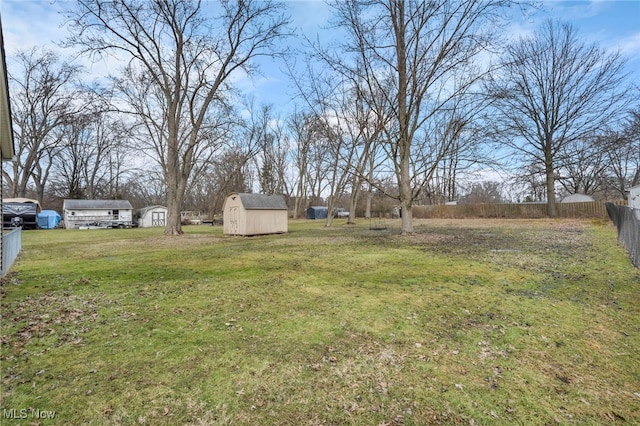 view of yard with a storage unit, an outdoor structure, and fence