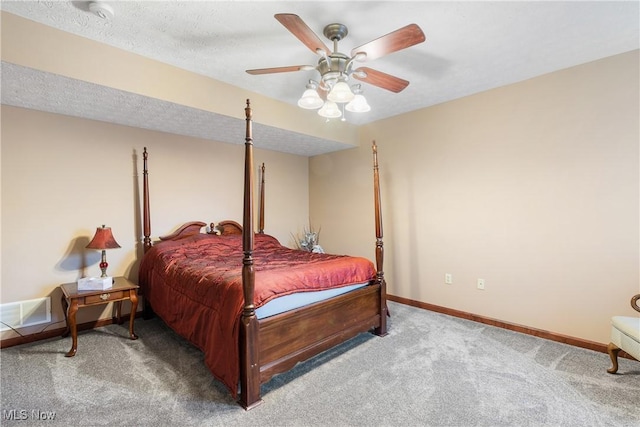 carpeted bedroom featuring a ceiling fan, baseboards, and a textured ceiling