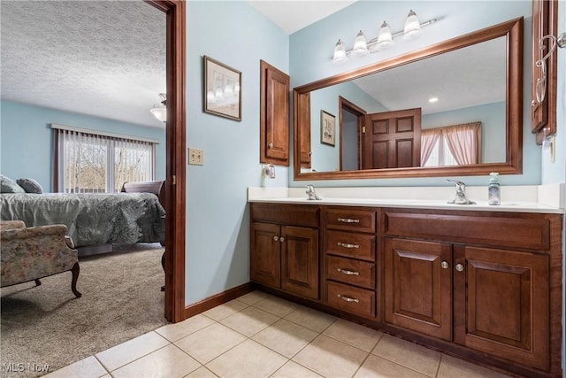 full bath with a sink, connected bathroom, double vanity, and tile patterned flooring