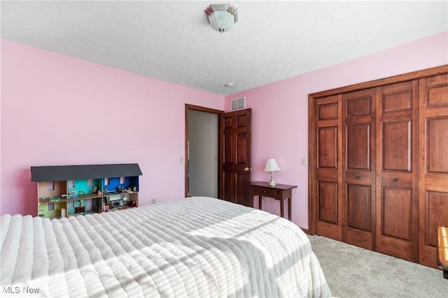 bedroom featuring a closet, visible vents, and carpet flooring