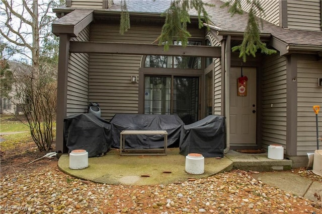 entrance to property featuring a shingled roof