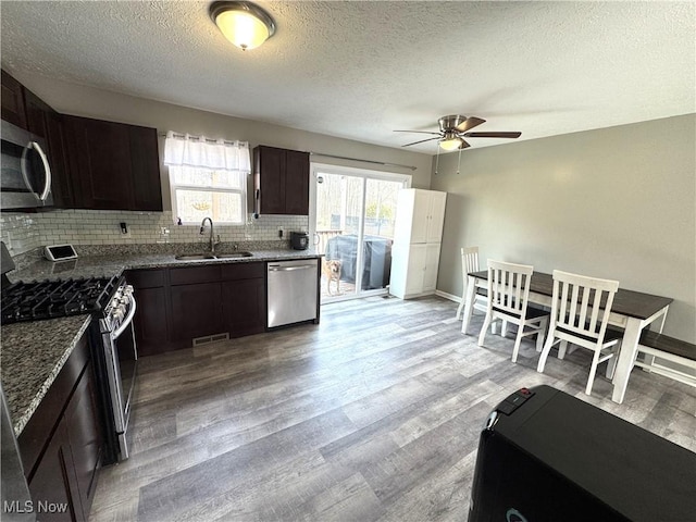 kitchen with light wood-type flooring, visible vents, stainless steel appliances, and a sink