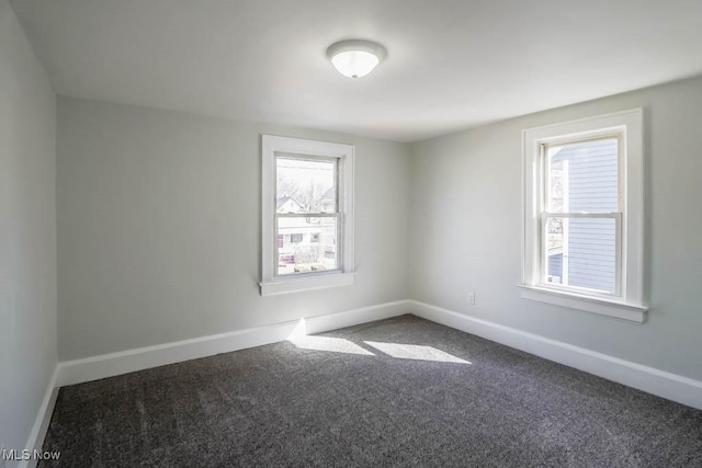 carpeted spare room featuring baseboards