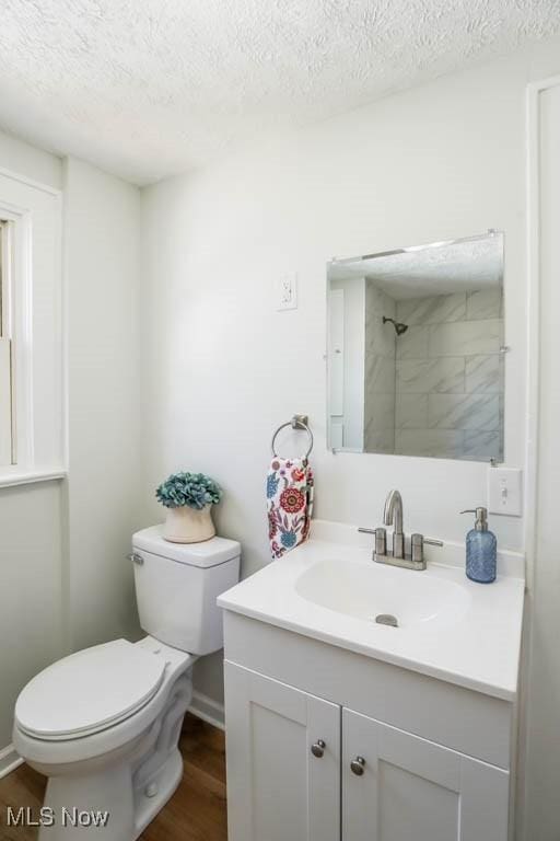 bathroom featuring a textured ceiling, vanity, wood finished floors, and toilet