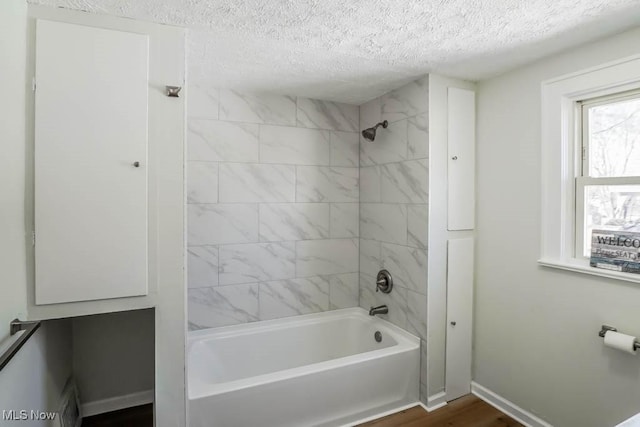 bathroom with  shower combination, a textured ceiling, baseboards, and wood finished floors