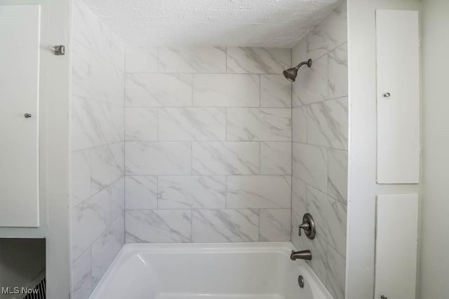 full bathroom featuring a textured ceiling and tub / shower combination