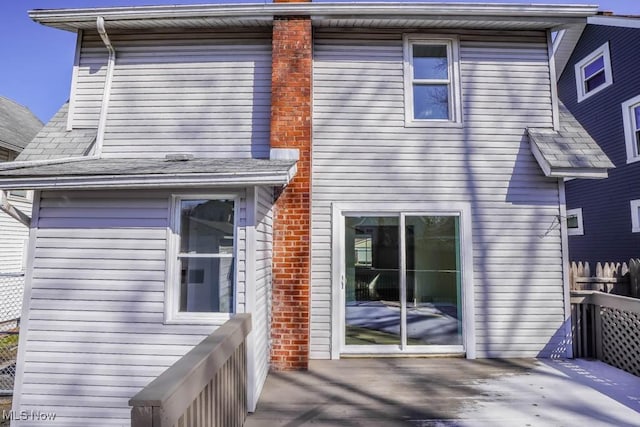 rear view of property featuring fence