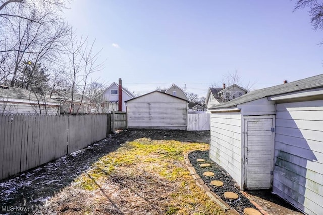 view of yard with an outbuilding, a fenced backyard, and a storage shed