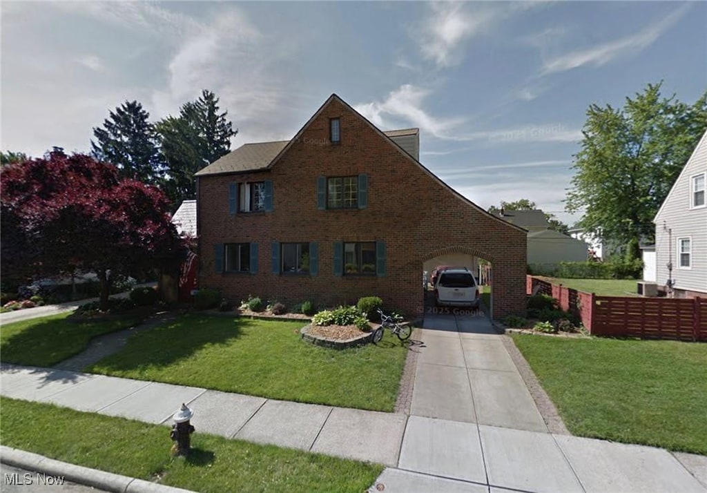 view of front of home featuring fence, a front lawn, concrete driveway, and brick siding