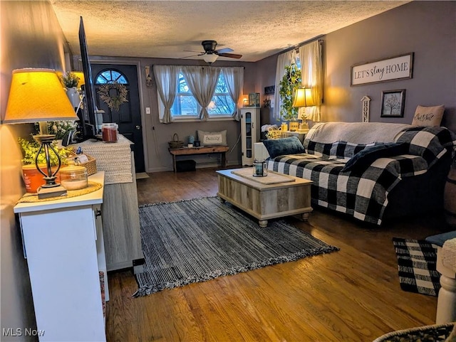 living room with a textured ceiling, a ceiling fan, and wood finished floors