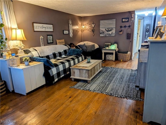 living room with a textured ceiling and wood-type flooring