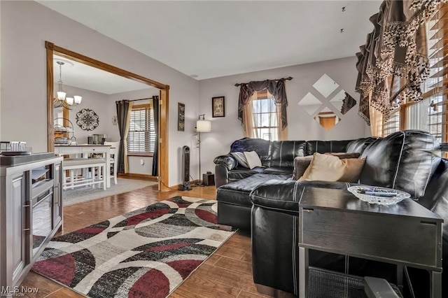 living room with plenty of natural light, wood finished floors, and a chandelier