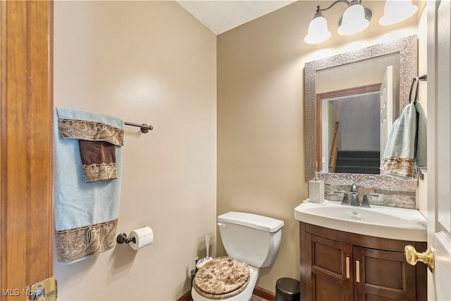 half bathroom featuring backsplash, vanity, and toilet