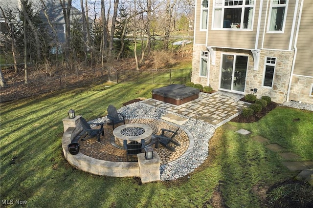 view of patio with an outdoor fire pit, fence, and a hot tub