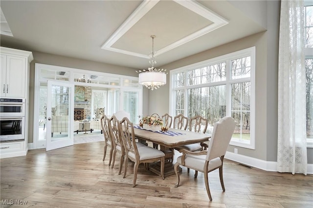 dining area with light wood-style floors, visible vents, plenty of natural light, and a notable chandelier