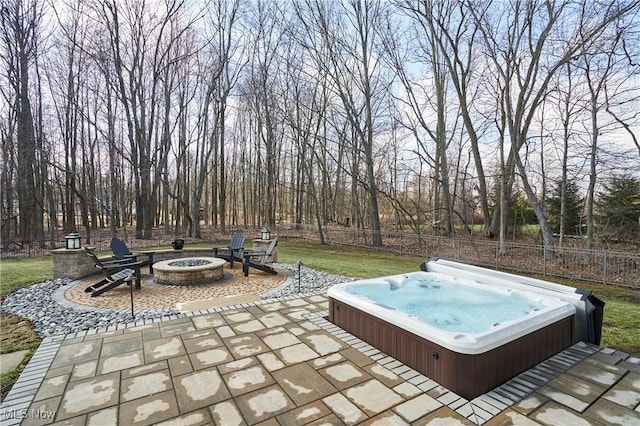 view of patio / terrace with a fire pit, an outdoor hot tub, and fence