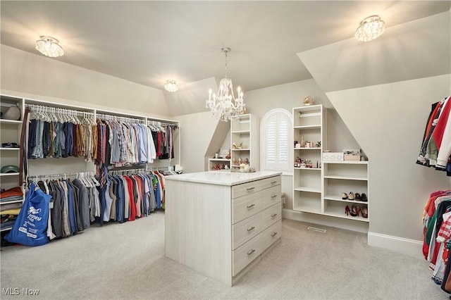 walk in closet with lofted ceiling, light carpet, and an inviting chandelier