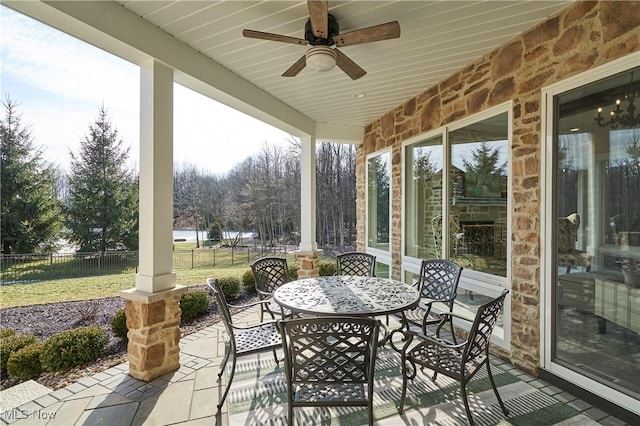 view of patio / terrace with ceiling fan, fence, and outdoor dining area