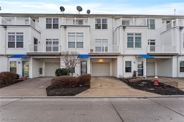 view of property featuring an attached garage and concrete driveway