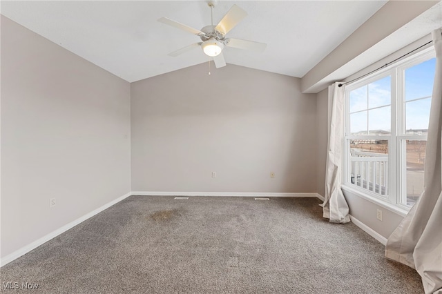 empty room with a ceiling fan, lofted ceiling, carpet flooring, and baseboards