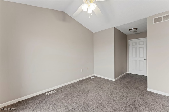 empty room featuring lofted ceiling, a ceiling fan, visible vents, baseboards, and dark carpet