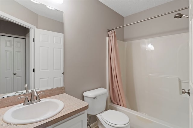 full bath featuring a textured ceiling, toilet, shower / bath combo with shower curtain, and vanity