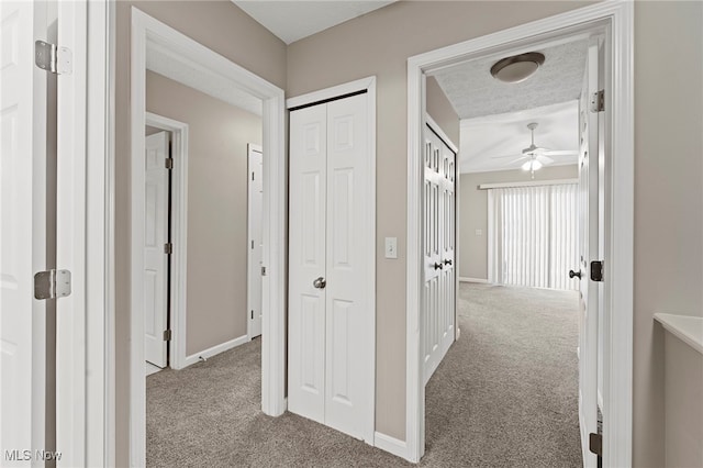 hall with carpet floors and baseboards