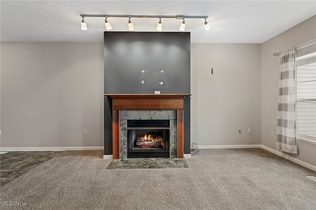 unfurnished living room featuring carpet floors, baseboards, and a premium fireplace