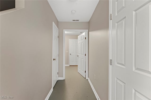 hallway with visible vents and baseboards