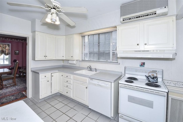 kitchen with white appliances, under cabinet range hood, light countertops, and a wall mounted air conditioner