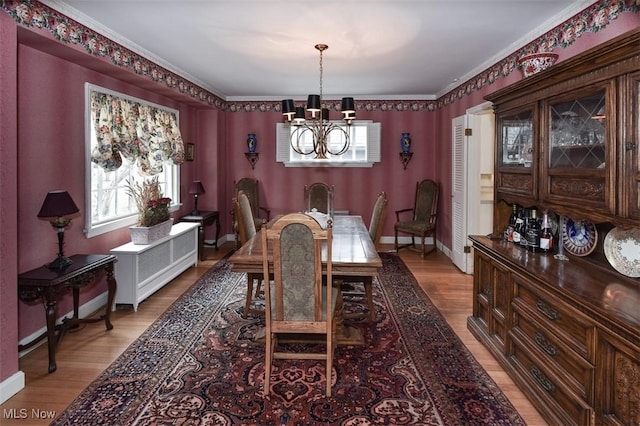 dining area featuring a chandelier, plenty of natural light, light wood-style flooring, and baseboards