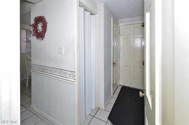 corridor with wallpapered walls and light tile patterned floors