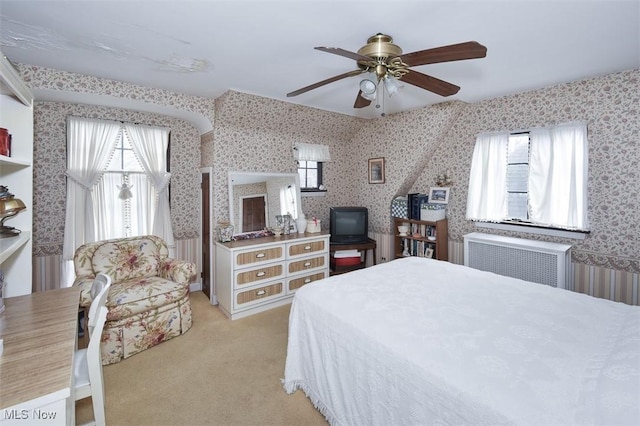 bedroom with light carpet, radiator, a ceiling fan, and wallpapered walls