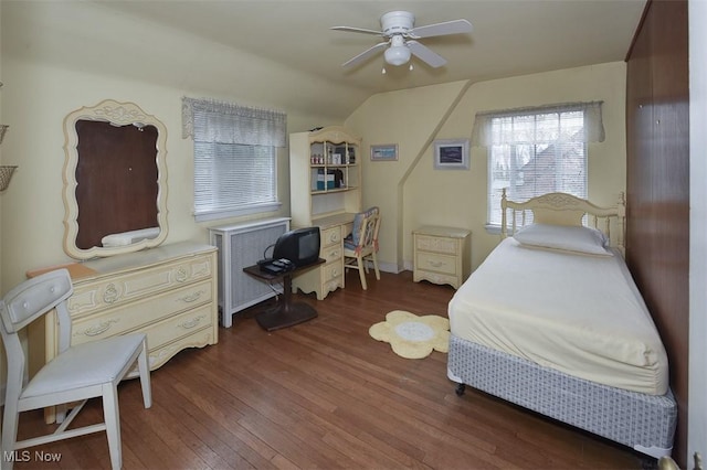 bedroom with a ceiling fan, lofted ceiling, radiator heating unit, and wood finished floors