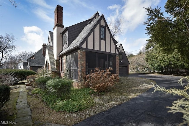 view of property exterior with a garage, a chimney, and stucco siding