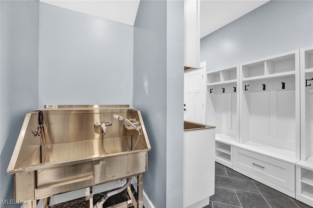 miscellaneous room featuring baseboards and dark tile patterned flooring