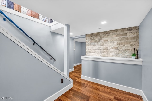 interior space featuring an accent wall, recessed lighting, wood finished floors, and baseboards