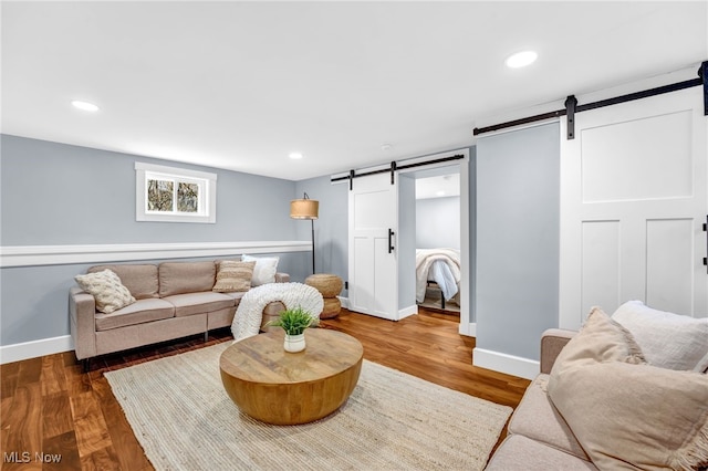 living room featuring recessed lighting, wood finished floors, and a barn door